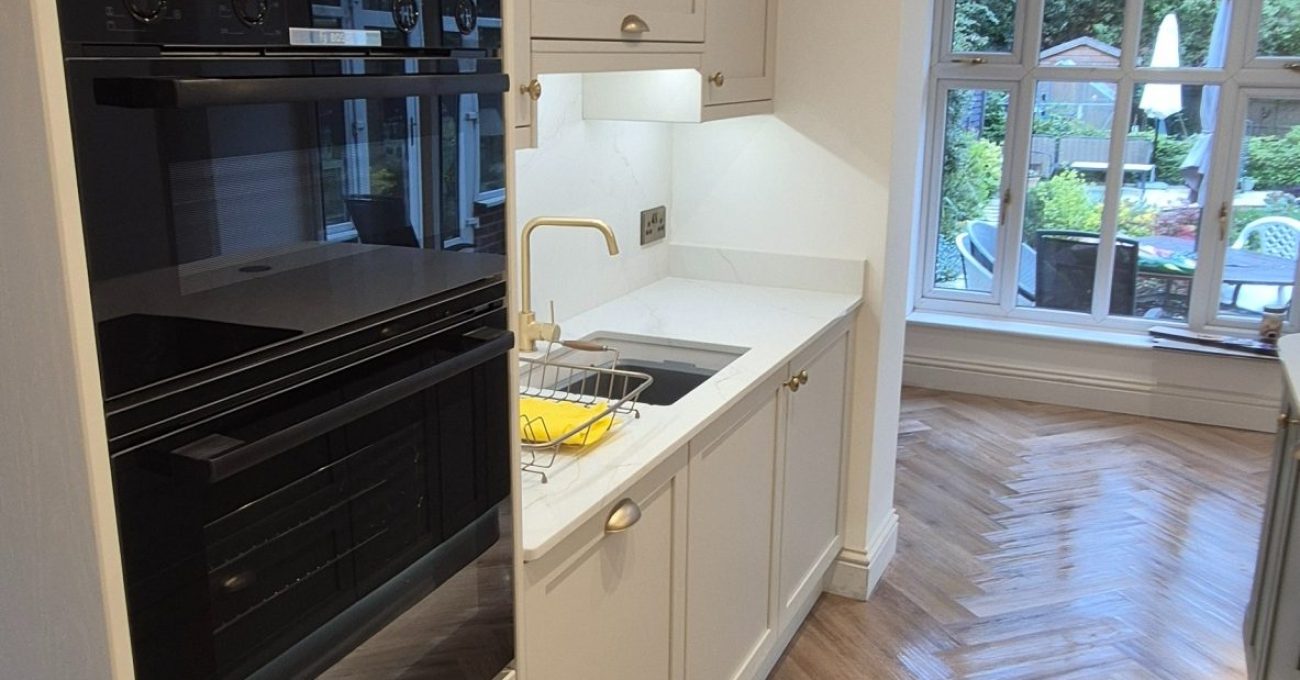 Modern painted Neves kitchen renovation in Wilmslow featuring quartz worktops, island and herringbone flooring.
